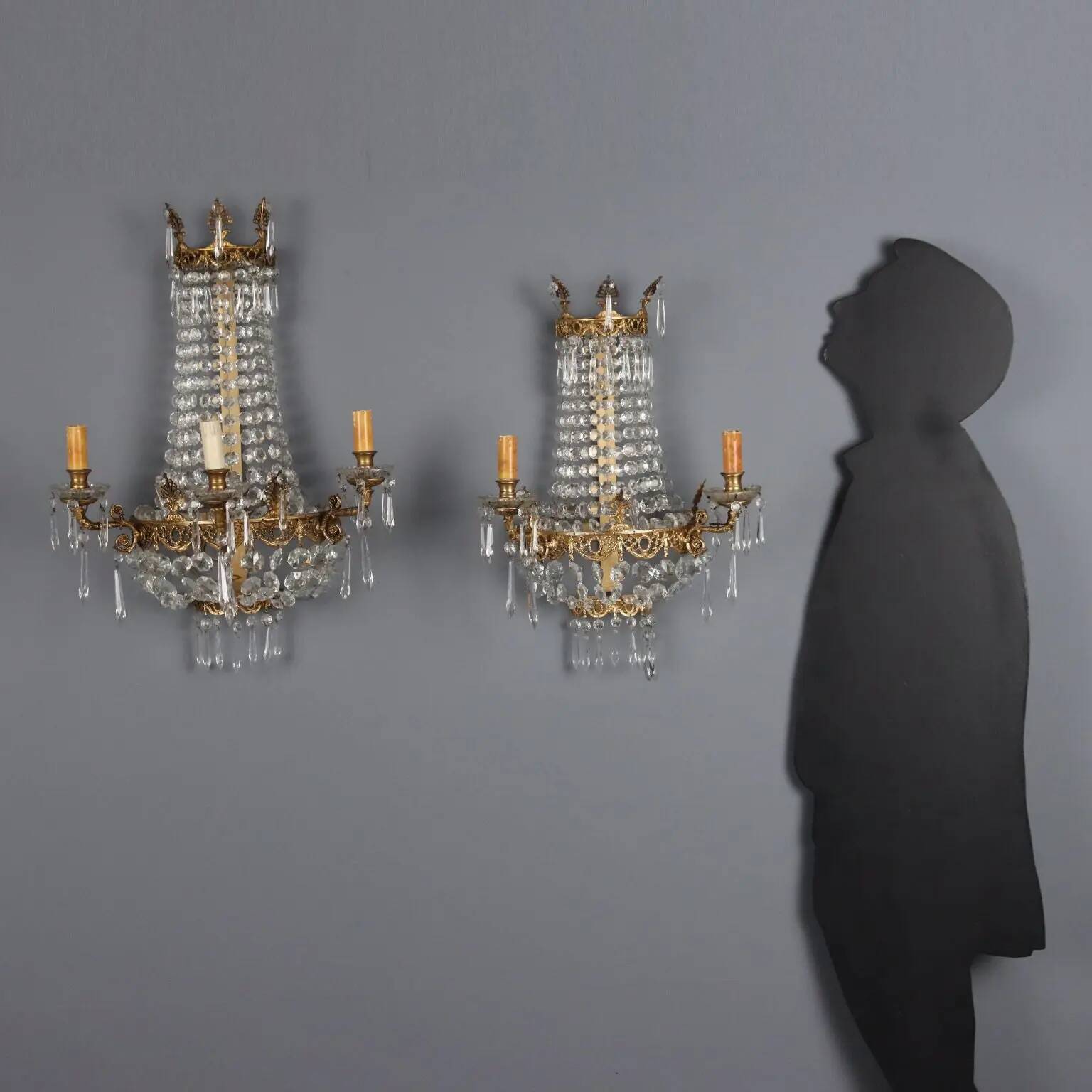 Antique wall sconces in gilded bronze with neoclassical motifs, 20th century.