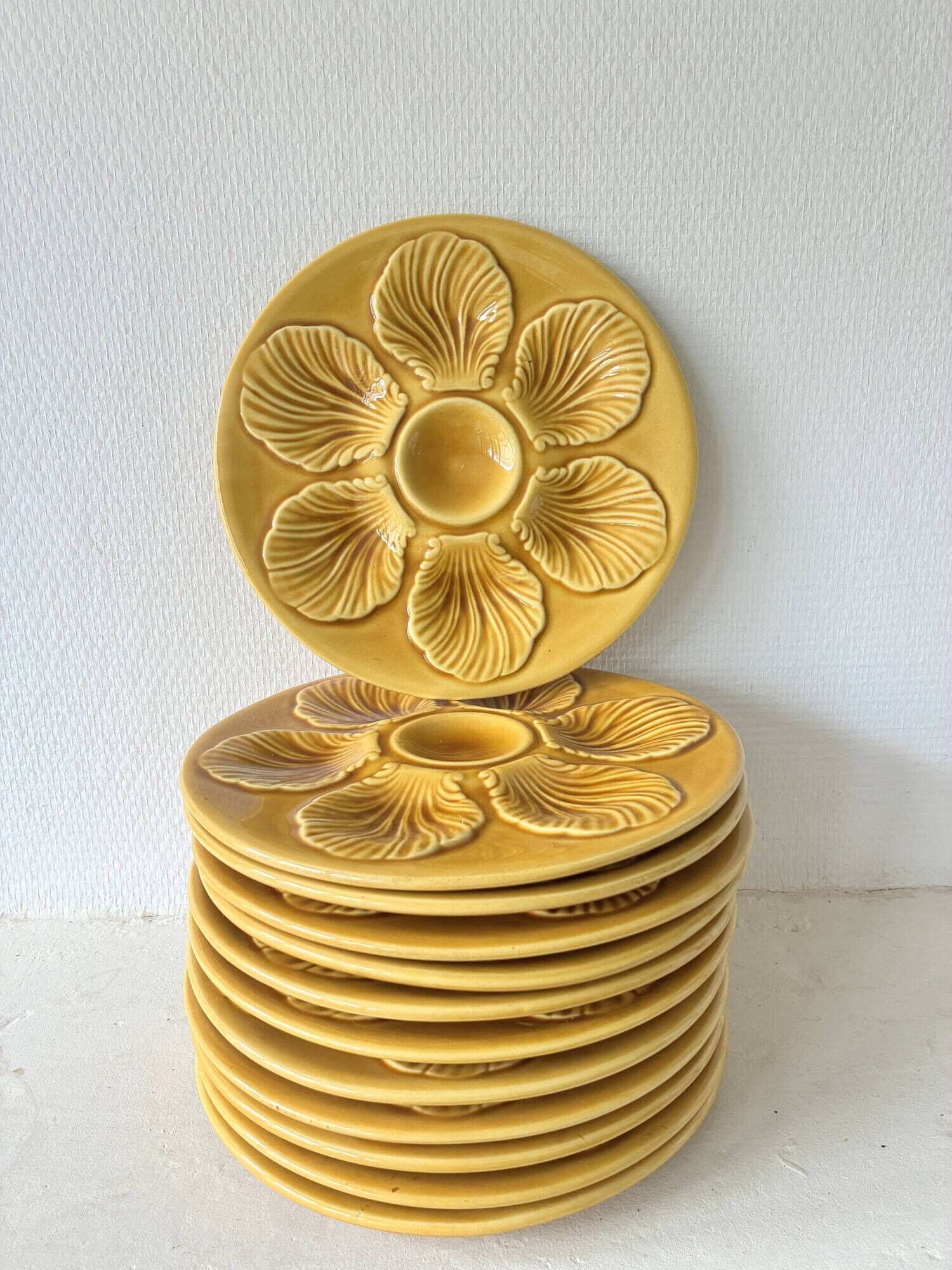 Lot of 12 shell-shaped plates, Barbotine, 1950s.