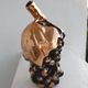 Beautiful black and gold ceramic bottle in the shape of a bunch of grapes.