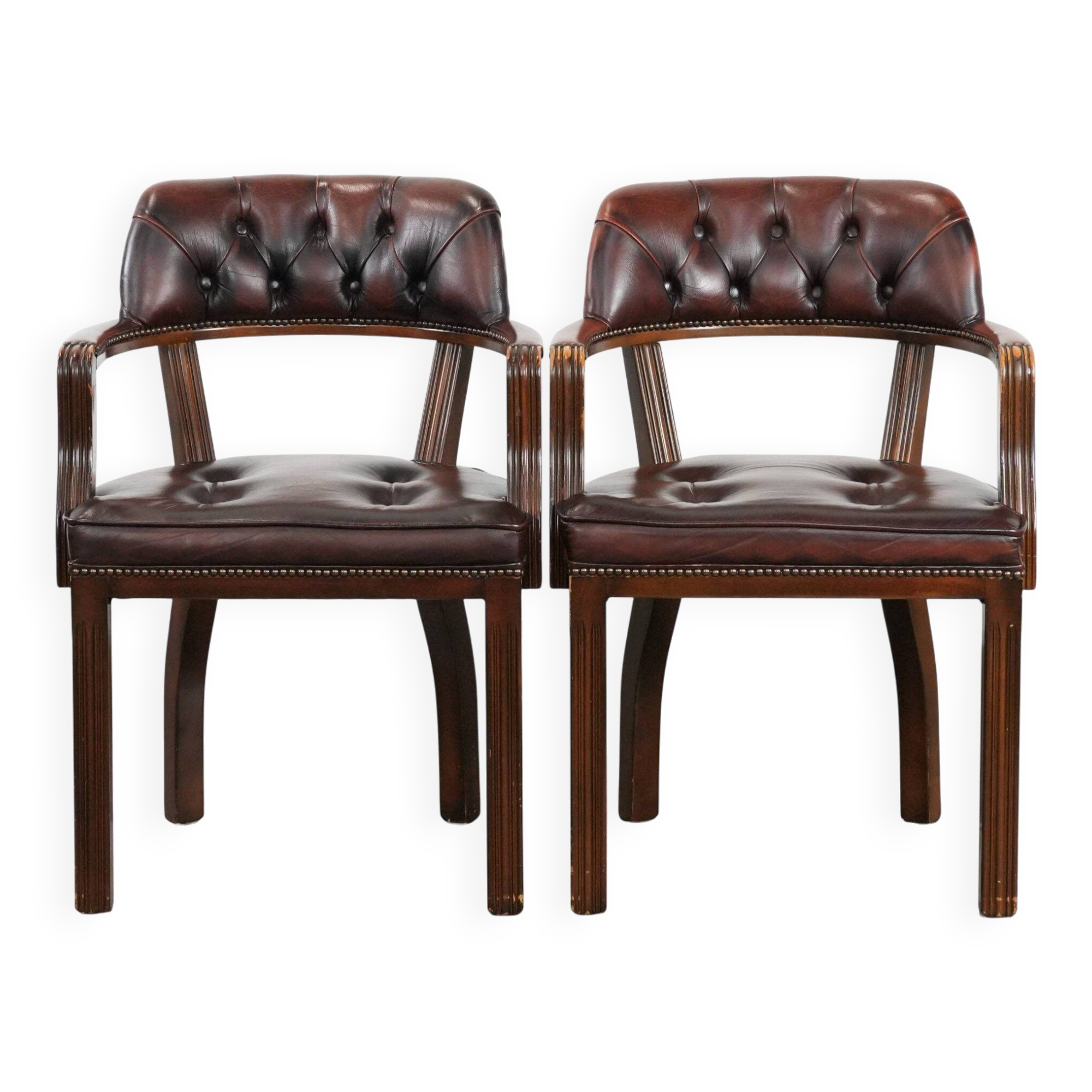 Set of two brown leather Chesterfield dining chairs in English style.