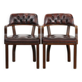 Set of two brown leather Chesterfield dining chairs in English style.