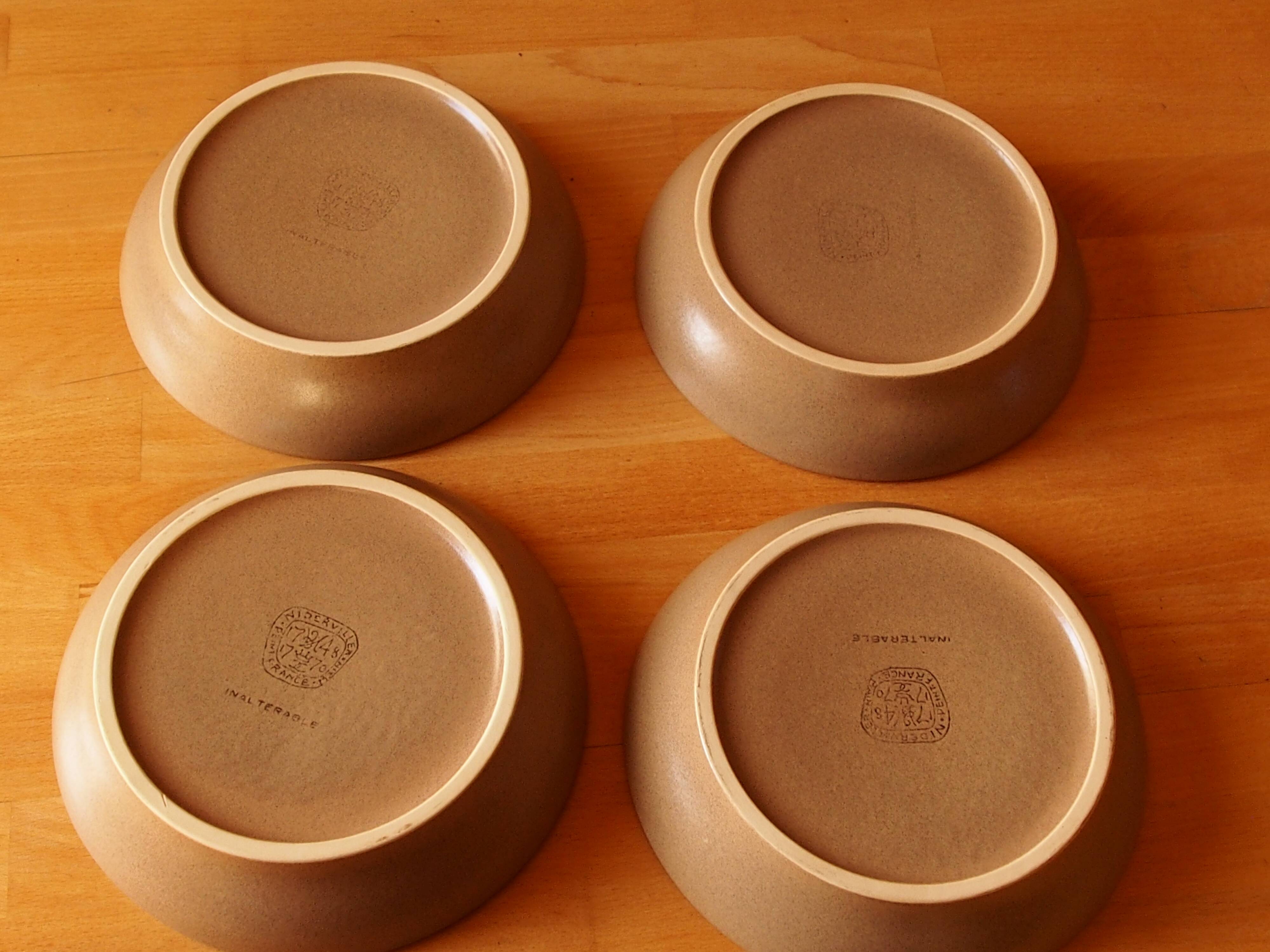 Four bowl-shaped plates in vintage Niderviller stoneware with plant decoration