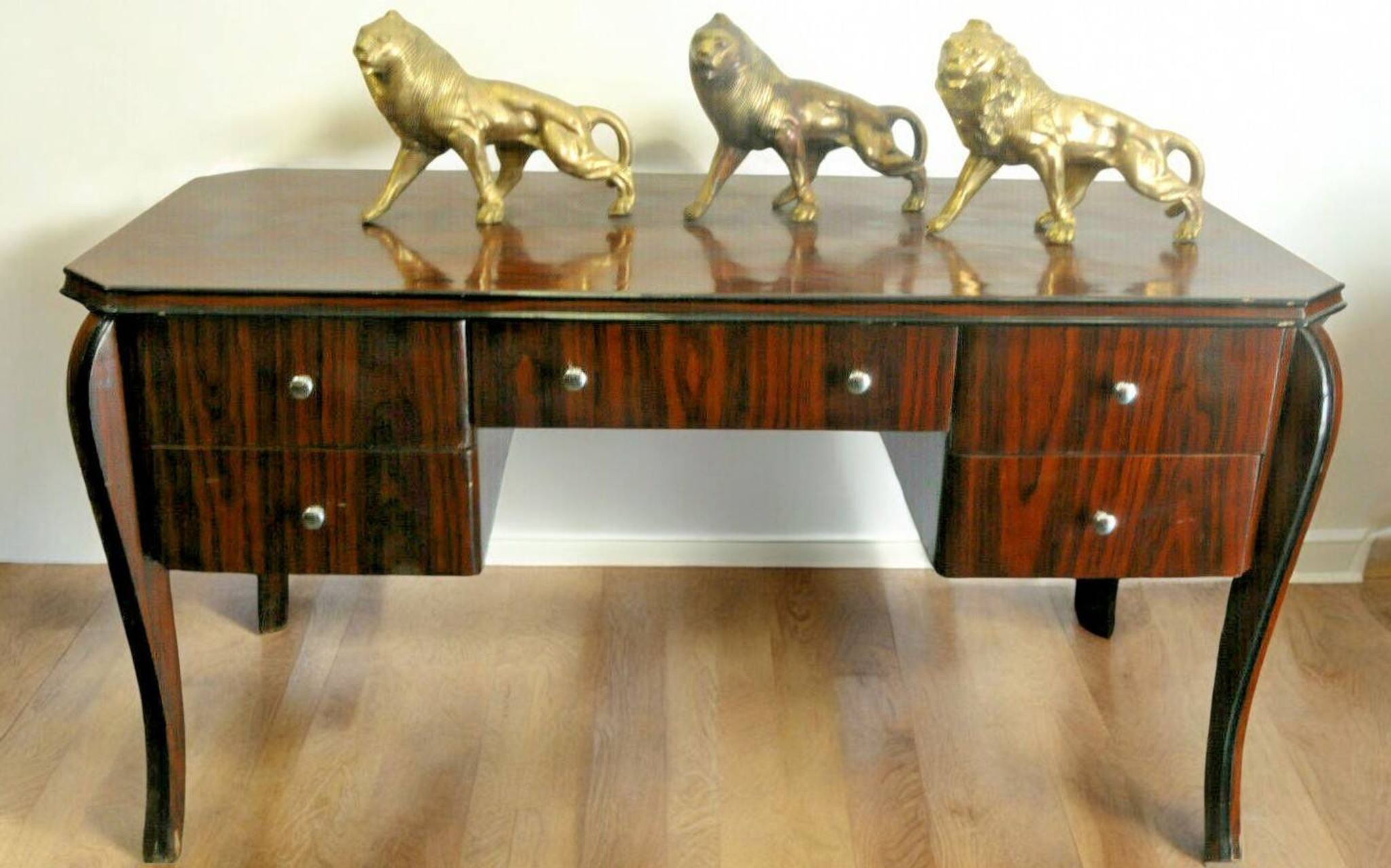A large Art Deco style rosewood desk with 5 drawers and decorative motifs