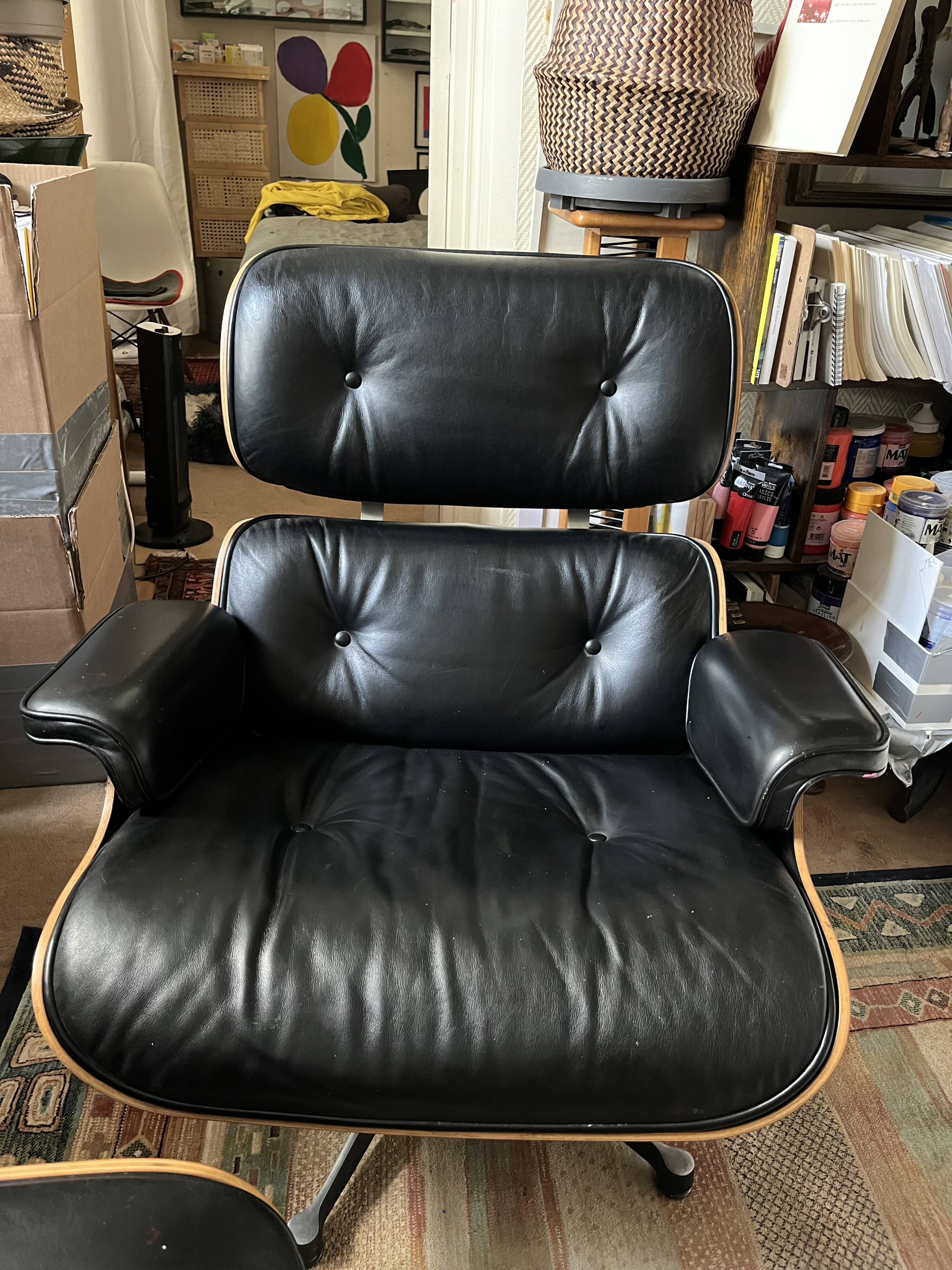Black leather Eames Vitra armchair, original with rosewood ottoman.