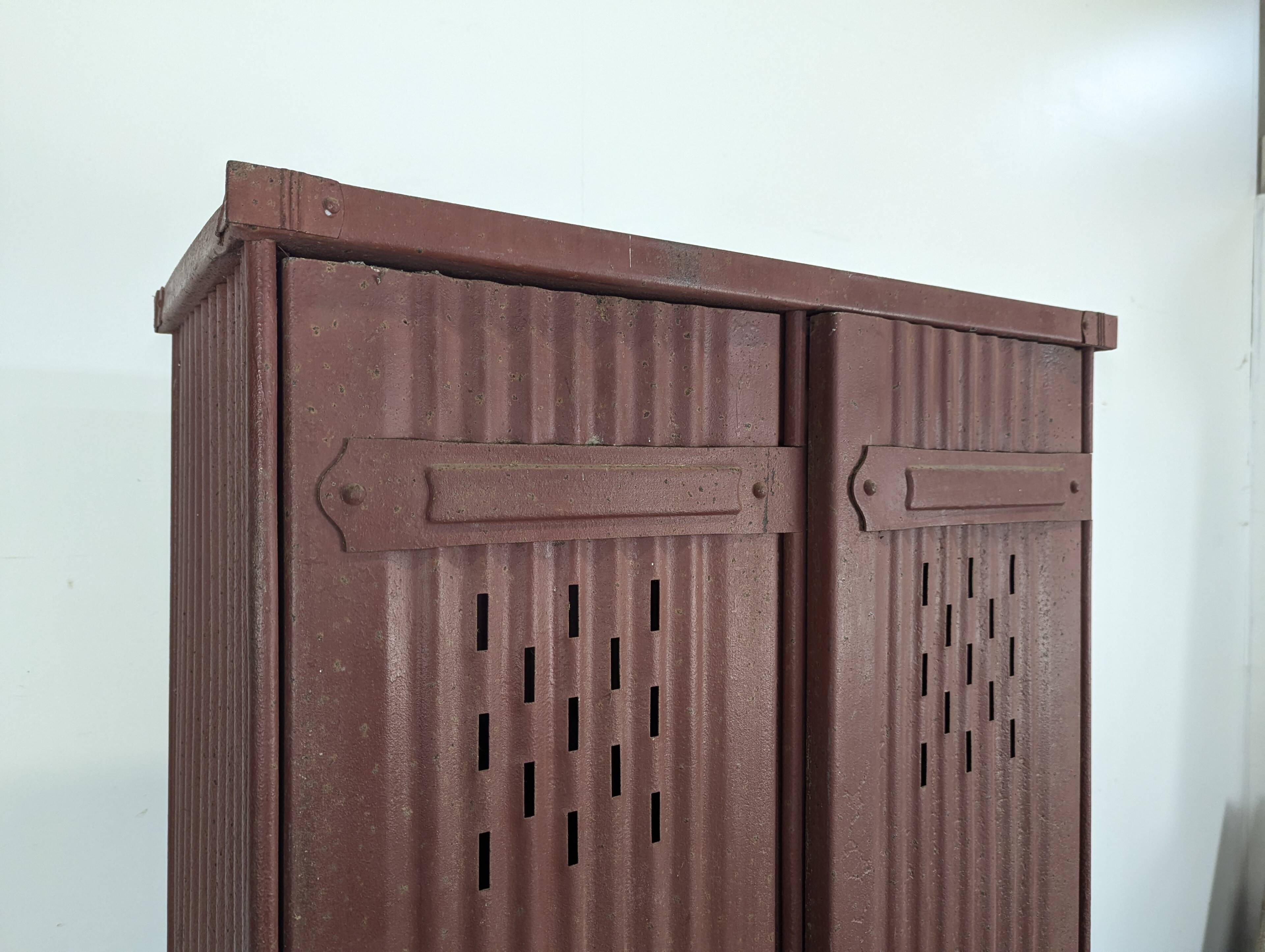 Red painted metal workshop locker with two doors.