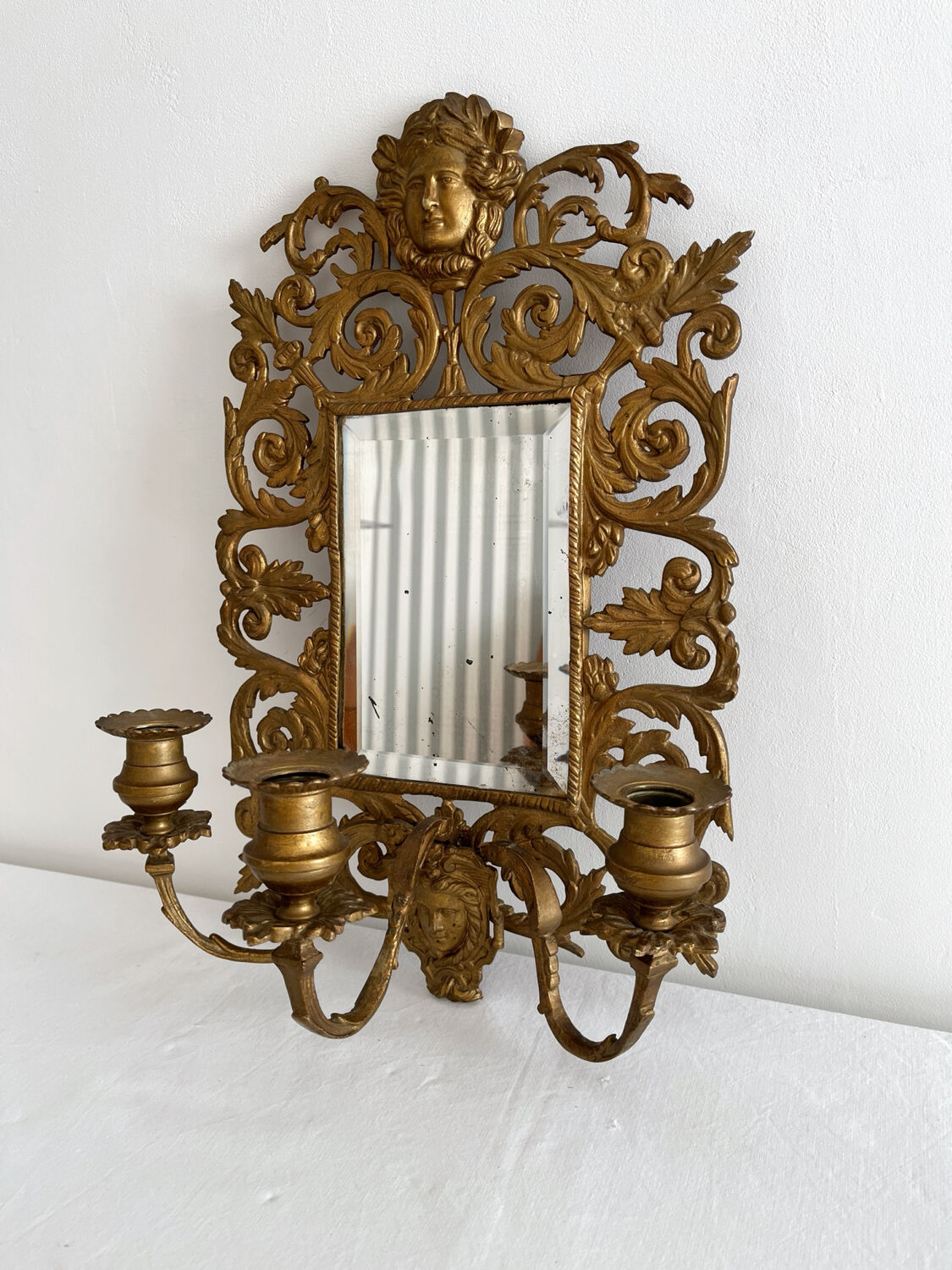 Bevelled mirror wall sconce in gilded bronze with 3 candle holders.