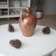 Old pitcher pitcher in varnished sandstone