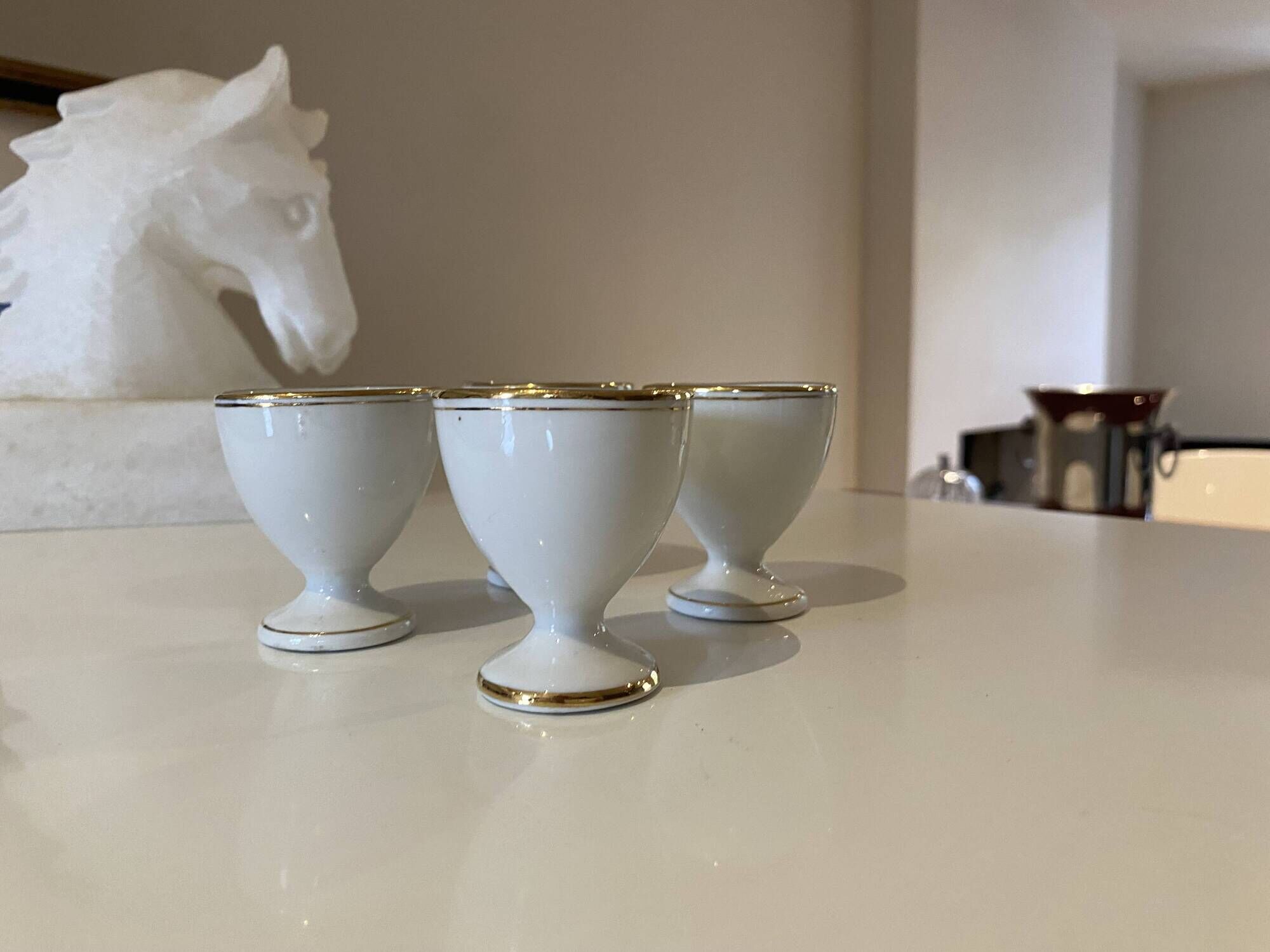 Set of 4 vintage egg cups in white porcelain with a gold rim.