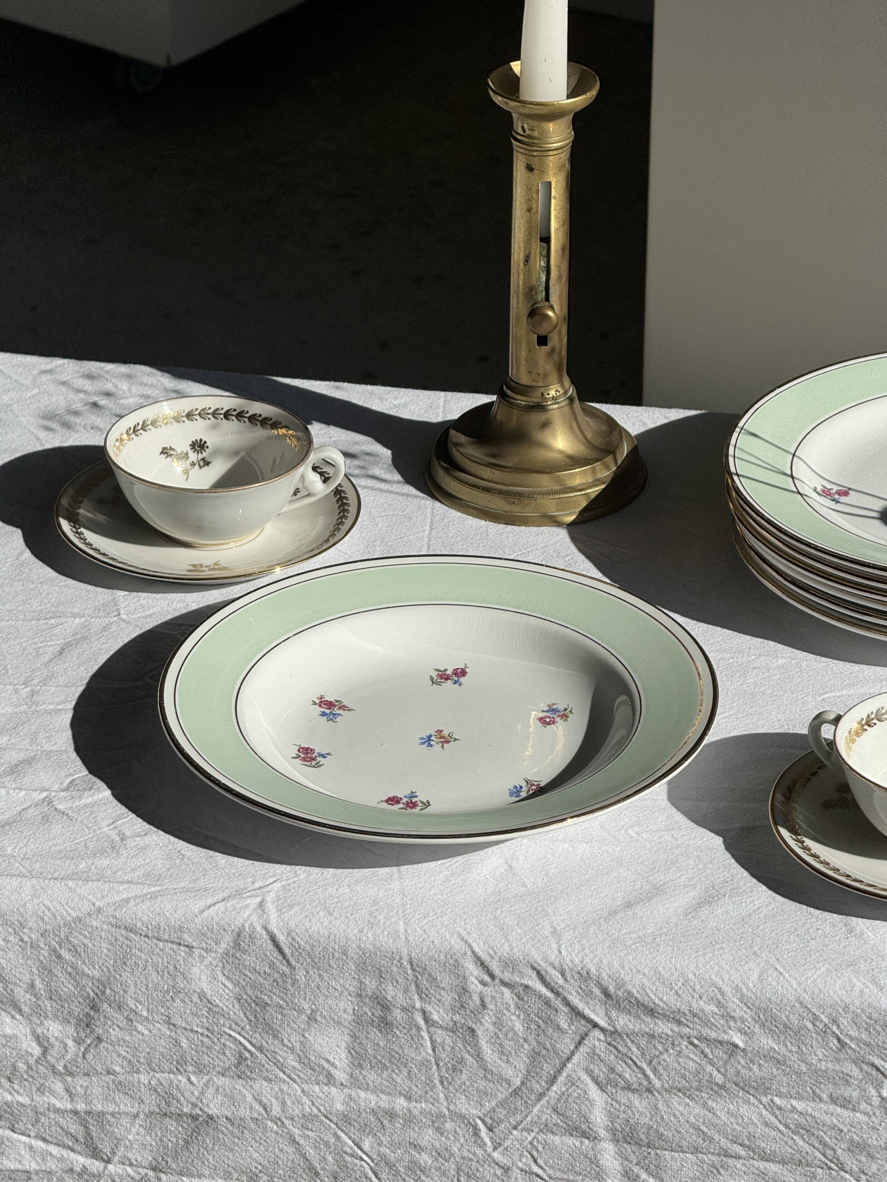 Set of 9 vintage turquoise deep plates with gold trim and pink flowers.