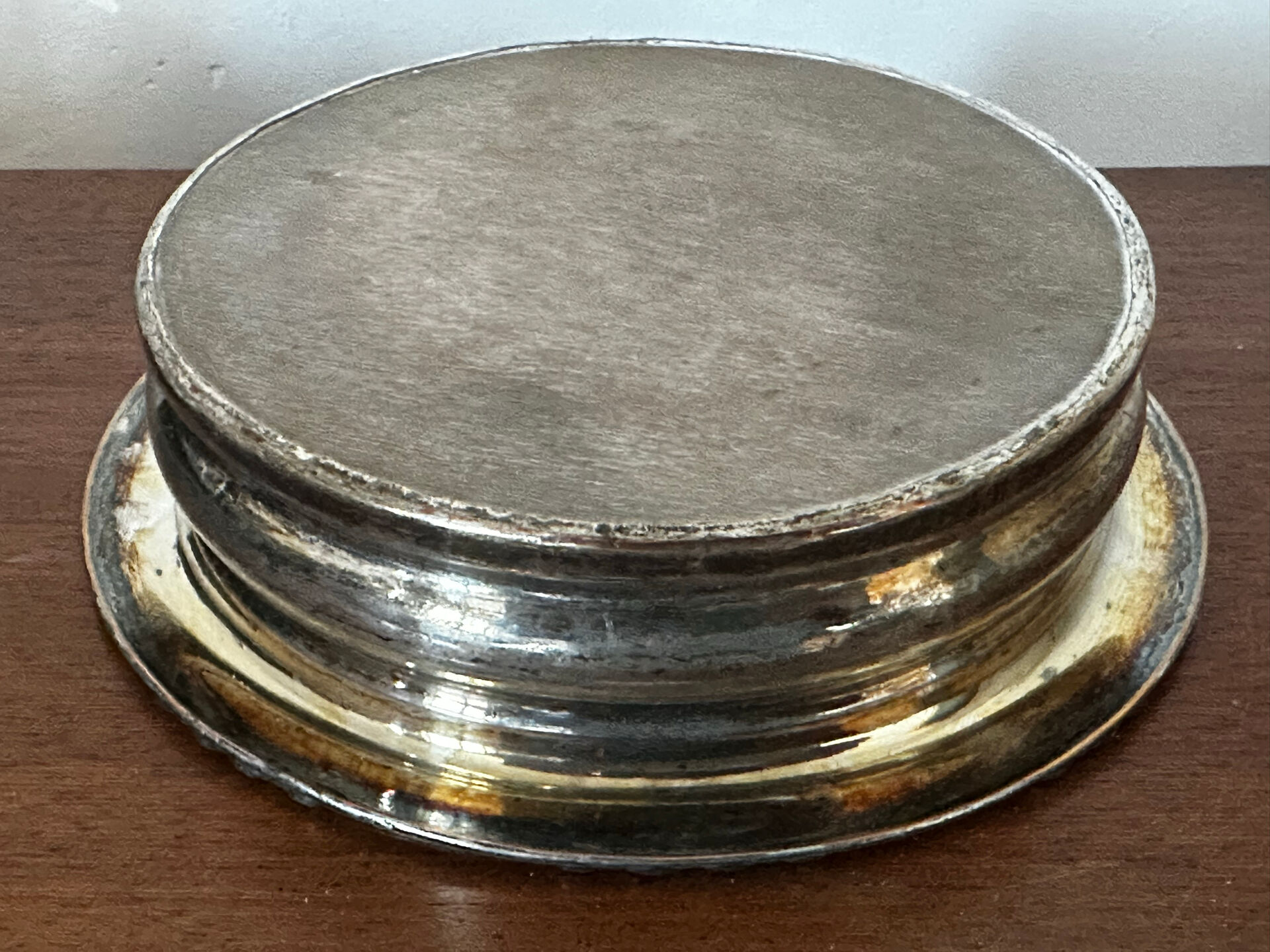 Antique silver-plated bottle coaster with floral decoration.