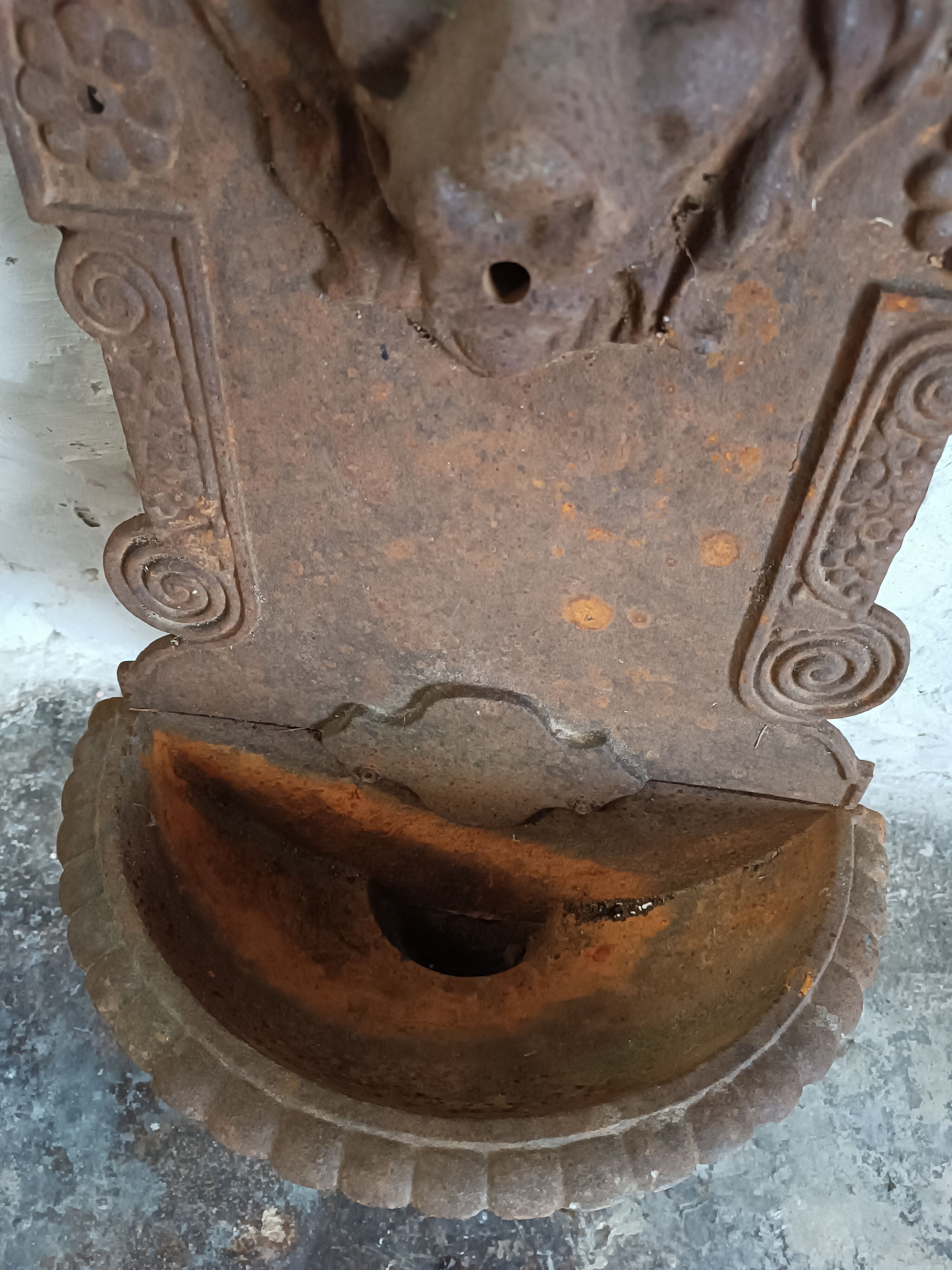 Old cast iron wall fountain with lion's head