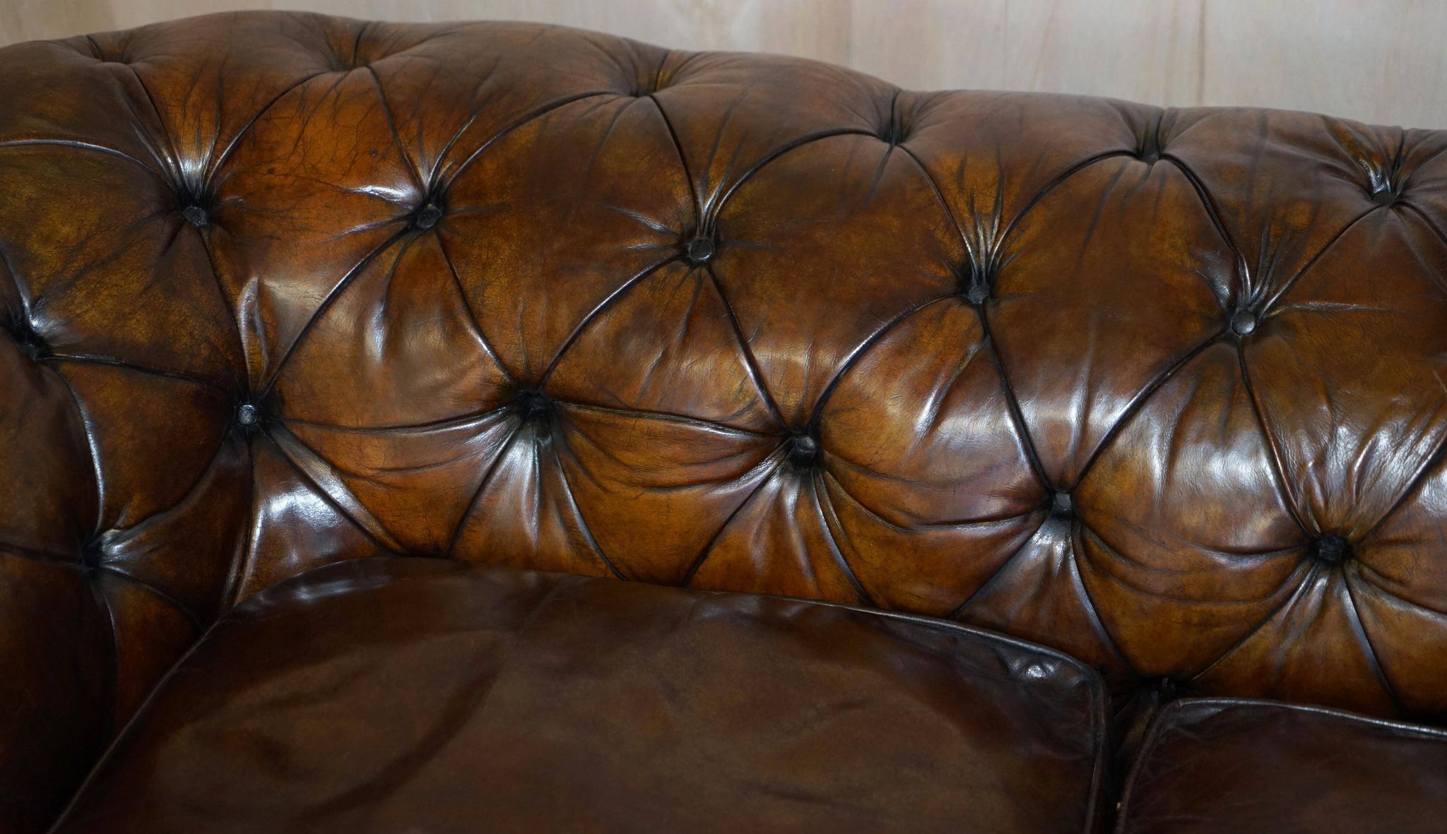 Victorian Chesterfield leather upholstered canapé with feather cushions.