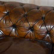 Victorian Chesterfield leather upholstered canapé with feather cushions.
