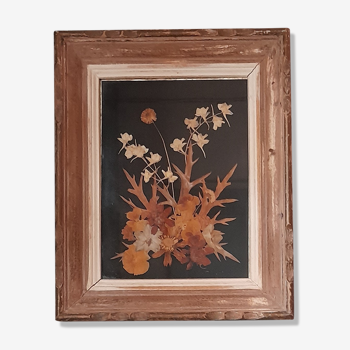 Wood frame dried flowers under glass, black background, vintage