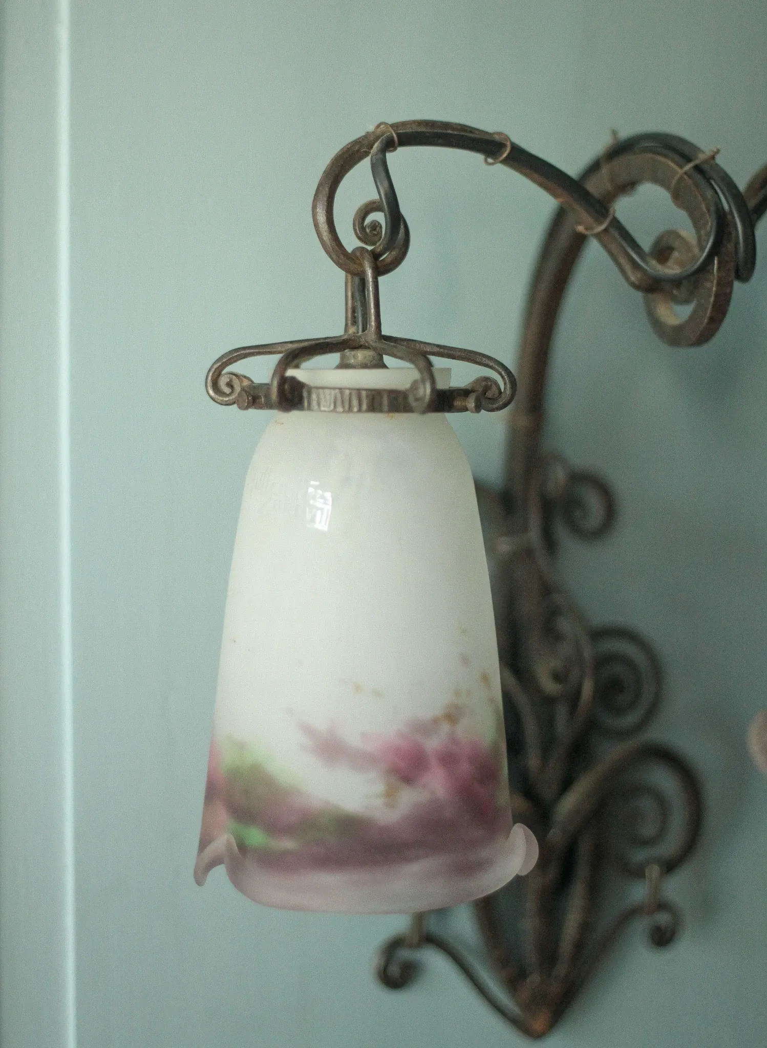 Wall lamp in wrought iron with a pink tulip glass globe by Muller glassworks.