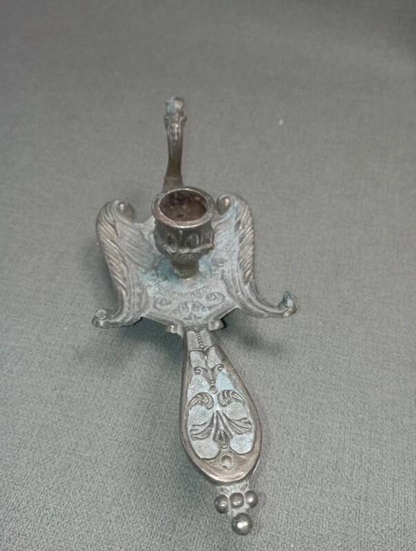 Chiselled brass candlestick in the shape of a peacock.