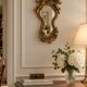 Antique rococo mirror with putti, gilded carved wood and stucco frame, 19th century.