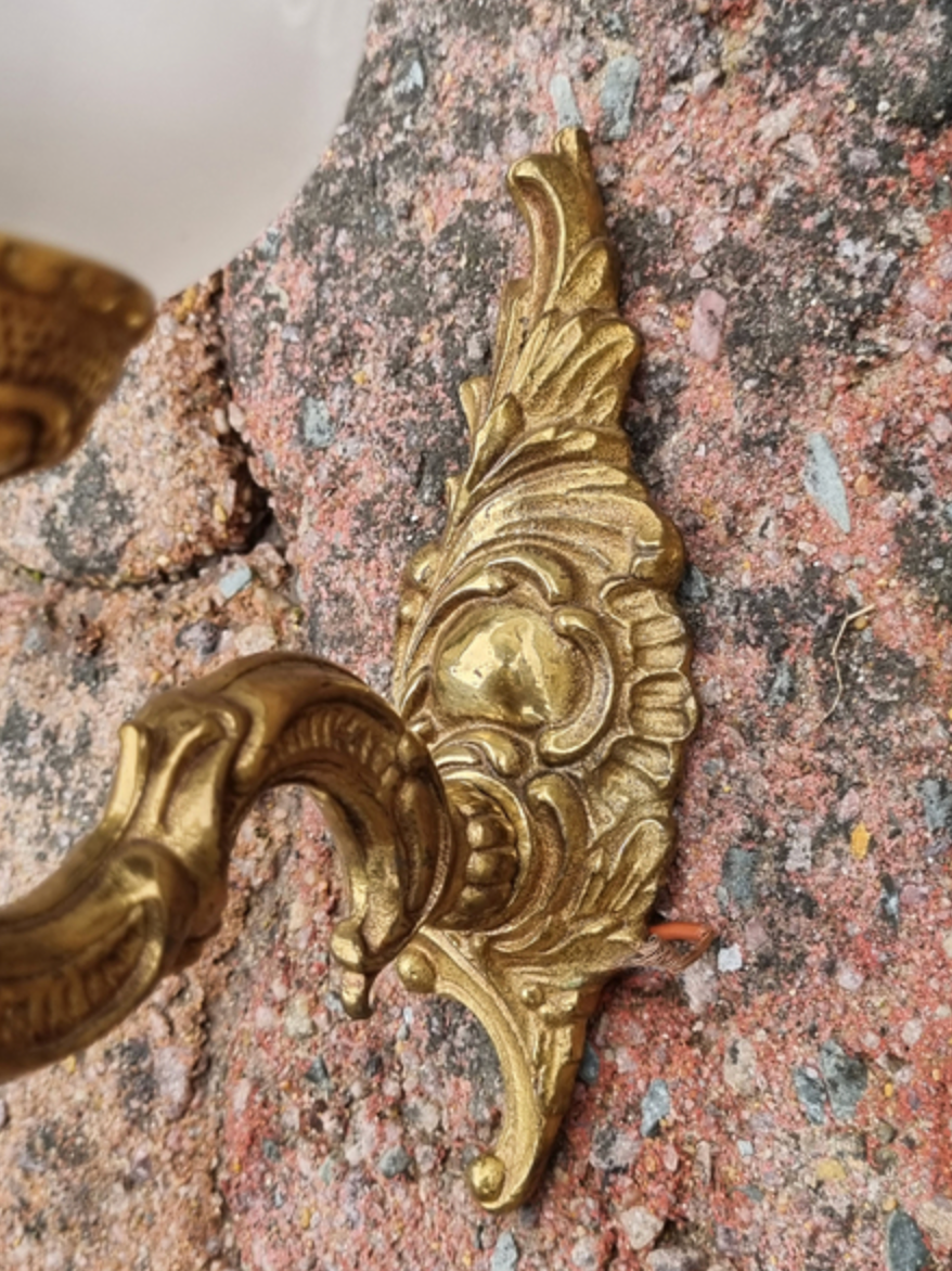 Pair of bronze wall lamps and frosted glass globe, early twentieth century.