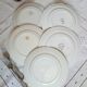 Old mismatched earthenware dinner plates with gold accompanied by a dish