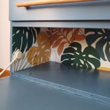 Blue sixties cabinet and monstera leaves