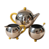 Ensemble de thé et café en acier inoxydable vintage des années 1980 avec accents jaunes, comprenant une théière, un crémier et un sucrier.