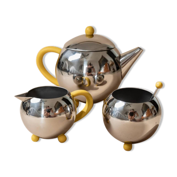 Ensemble de thé et café en acier inoxydable vintage des années 1980 avec accents jaunes, comprenant une théière, un crémier et un sucrier.