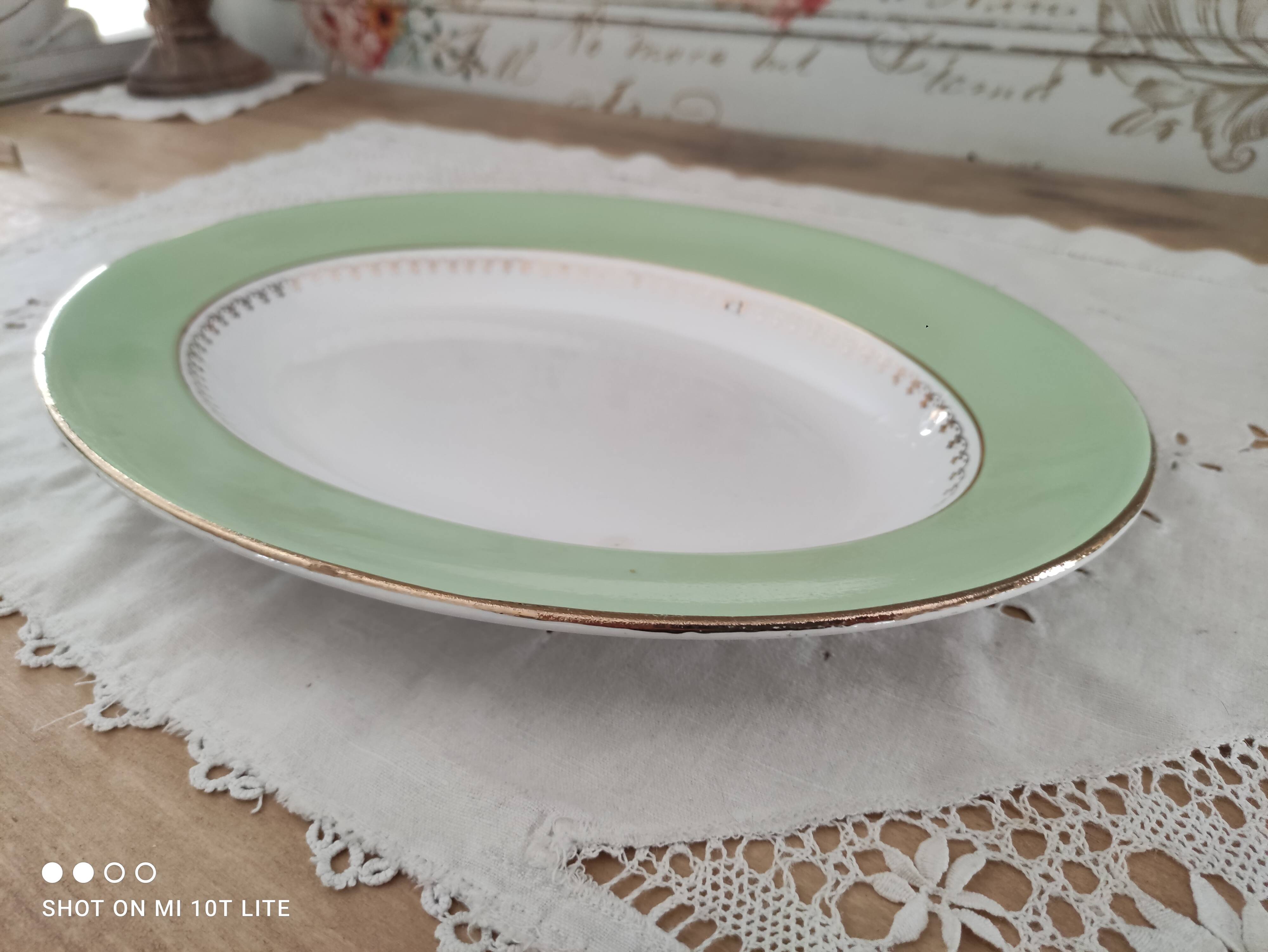 Oval plate with a light green rim and golden frieze, Cafés Lemaire.