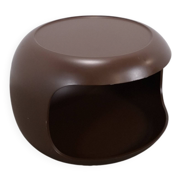 Brown round space age table on wheels with an open compartment.