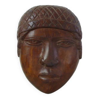 Face sculpture in raw wood