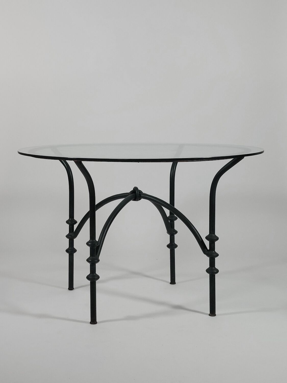 Table à manger vintage avec base tubulaire et plateau en verre avec un nœud.