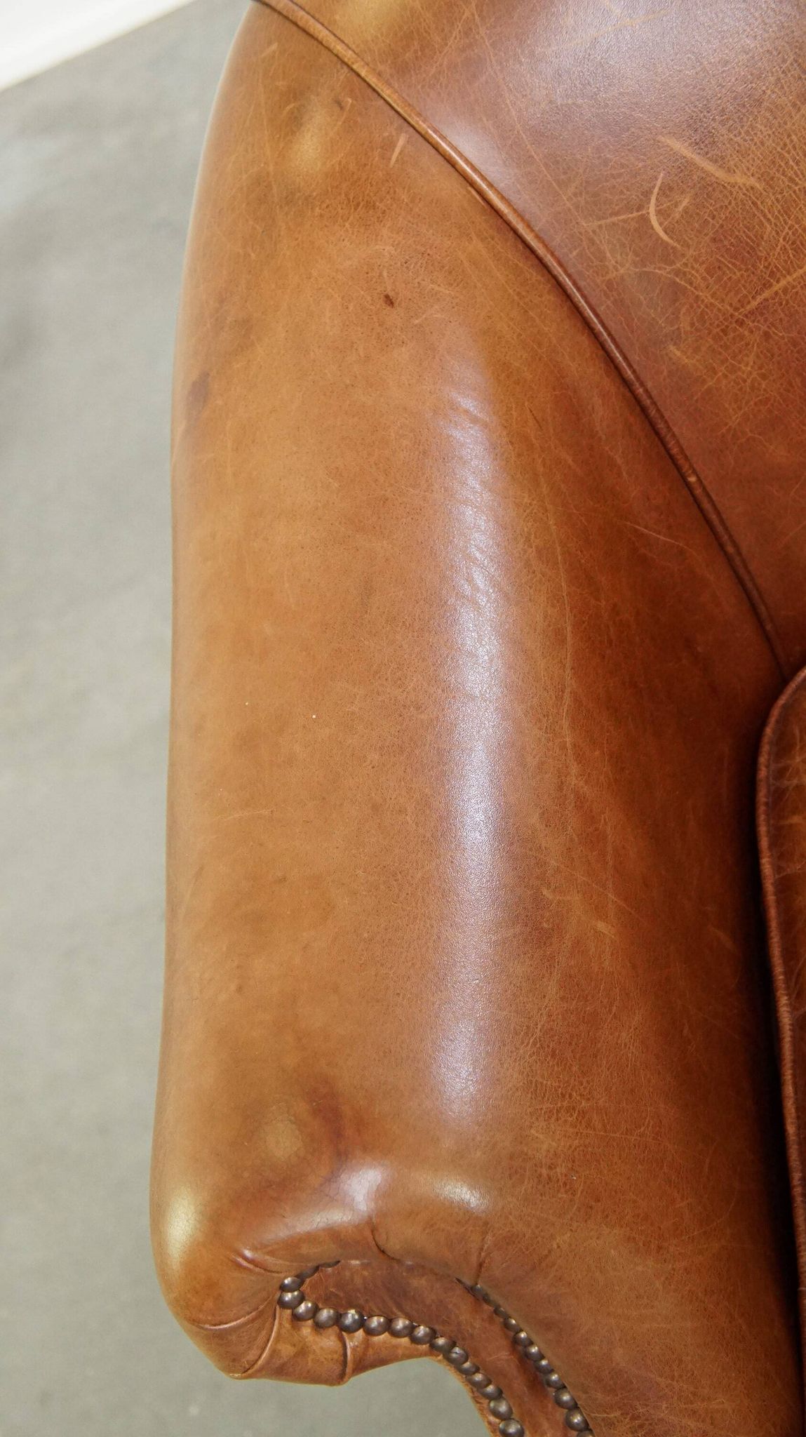 Very comfortable, elegant leather club armchair with a removable seat cushion and timeless design