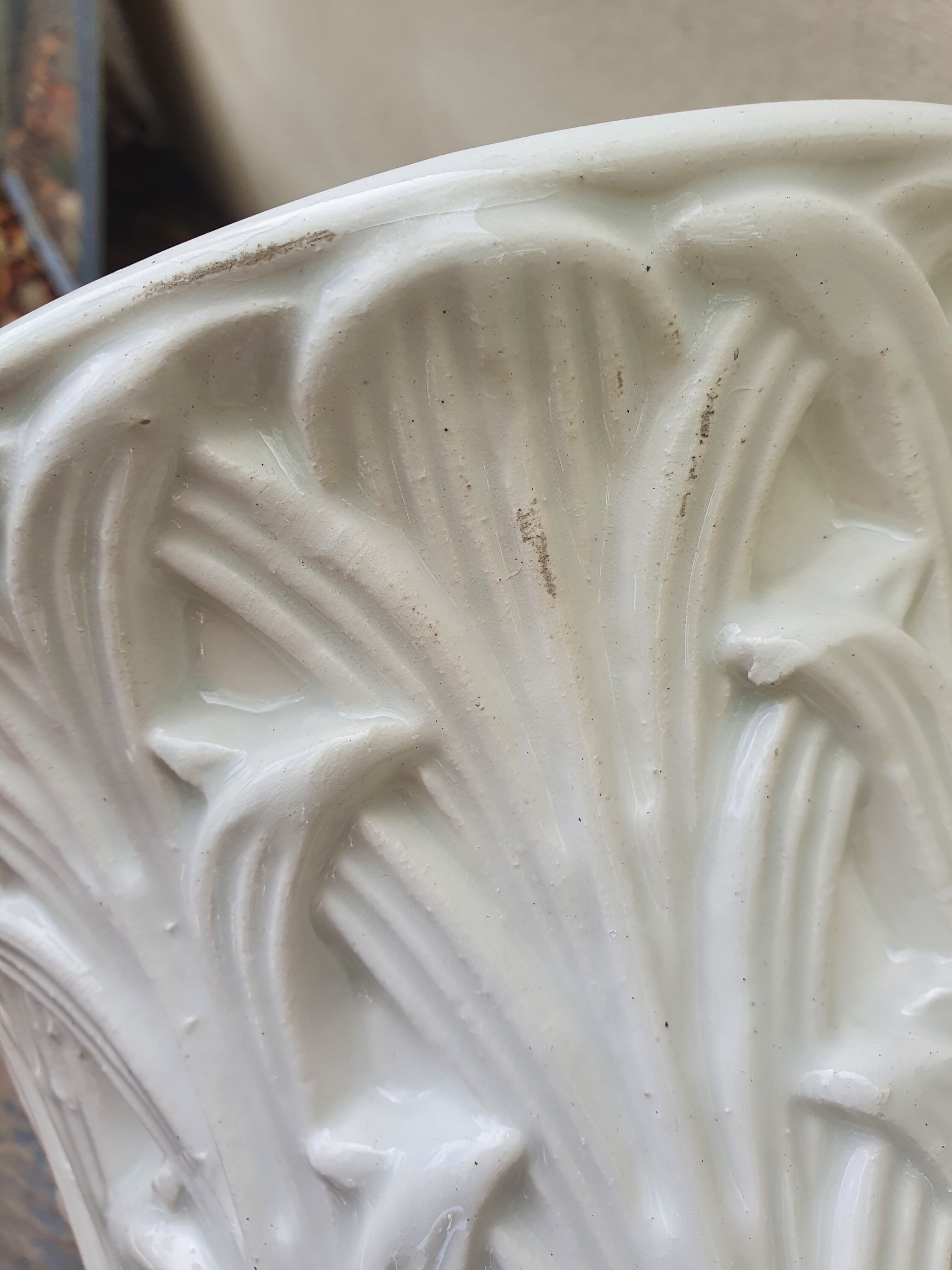 Important white earthenware pot cache with leafy decoration
