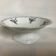Old shower tray with silver trim and forget-me-not flowers.