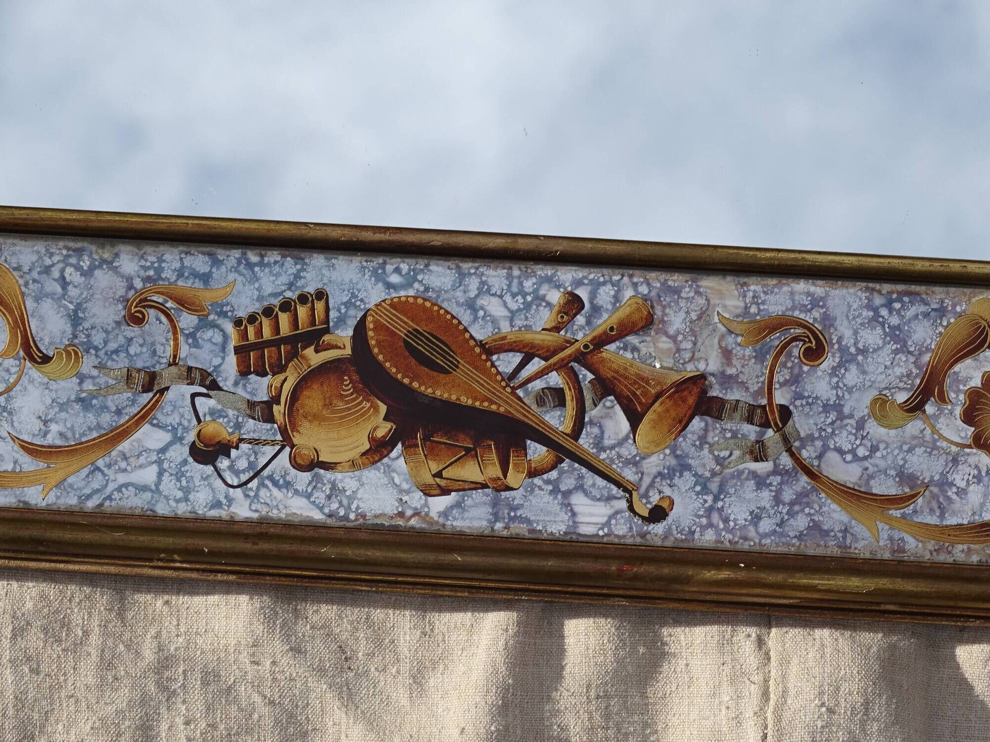 50s Eglomisé glass mirror with musical instrument decor