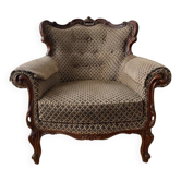 Baroque armchair in carved wood and geometric fabric.