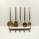 5 kitchen utensils and a brass wall mount