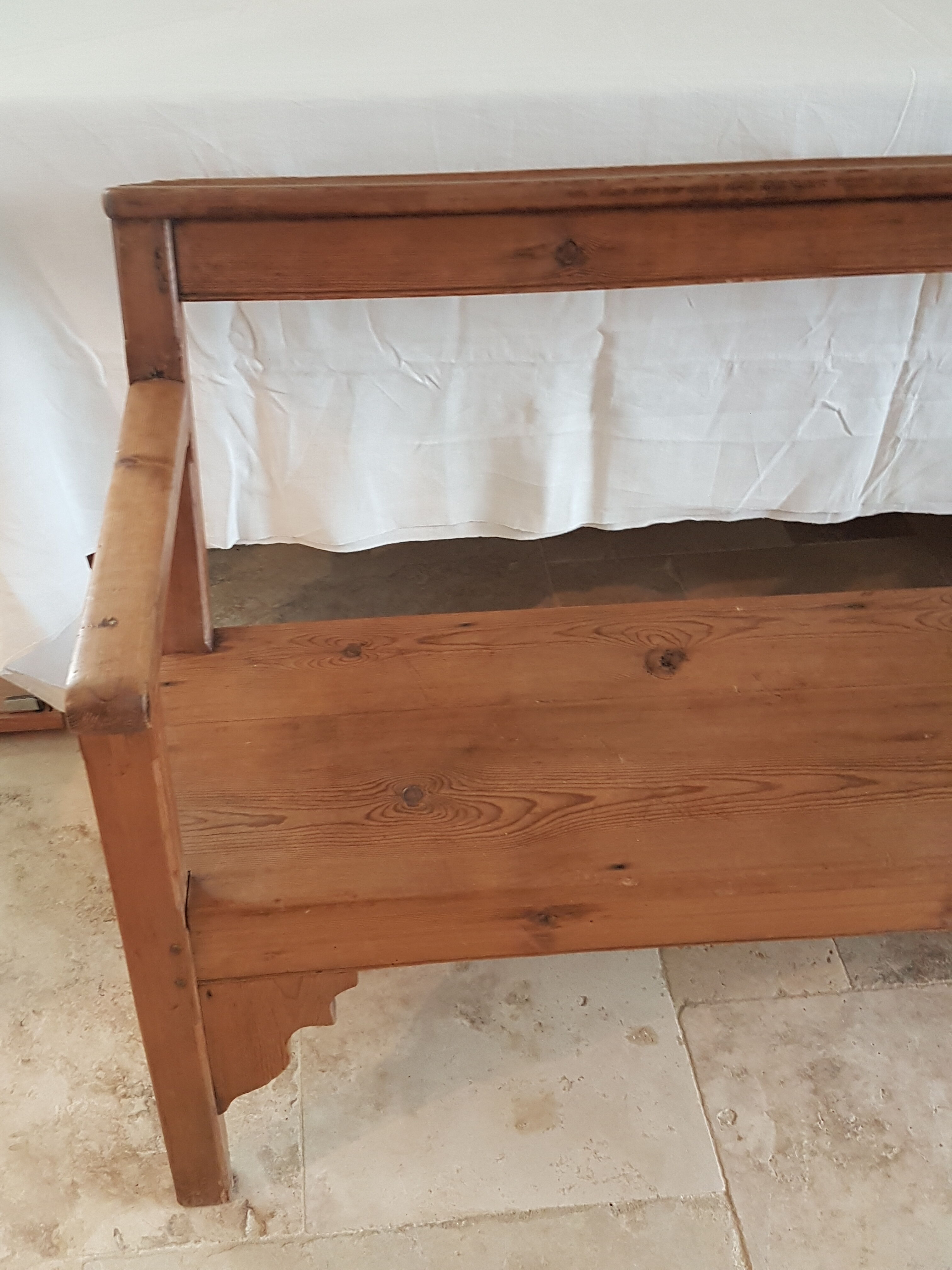 Church bench in fir tree with armrests
