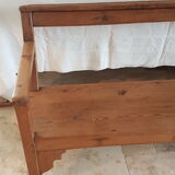 Church bench in fir tree with armrests