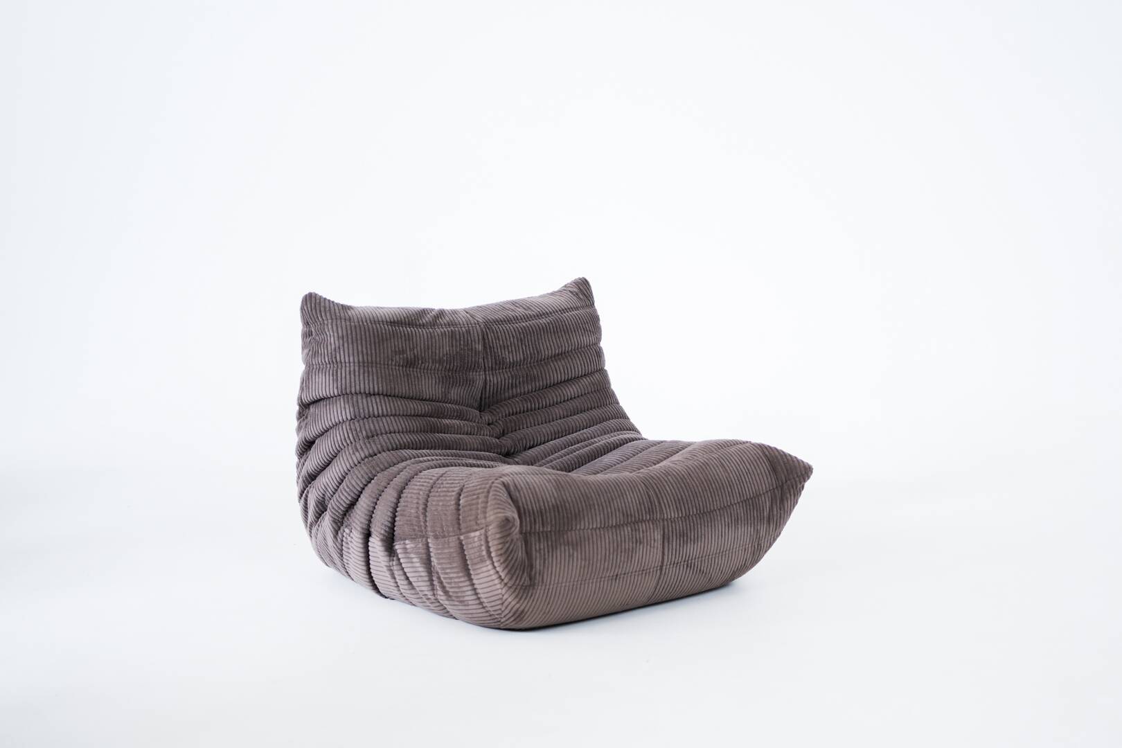 Ensemble de chaise et pouf Togo en velours côtelé marron.