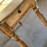 Oval wooden table with drop-leaf edges.