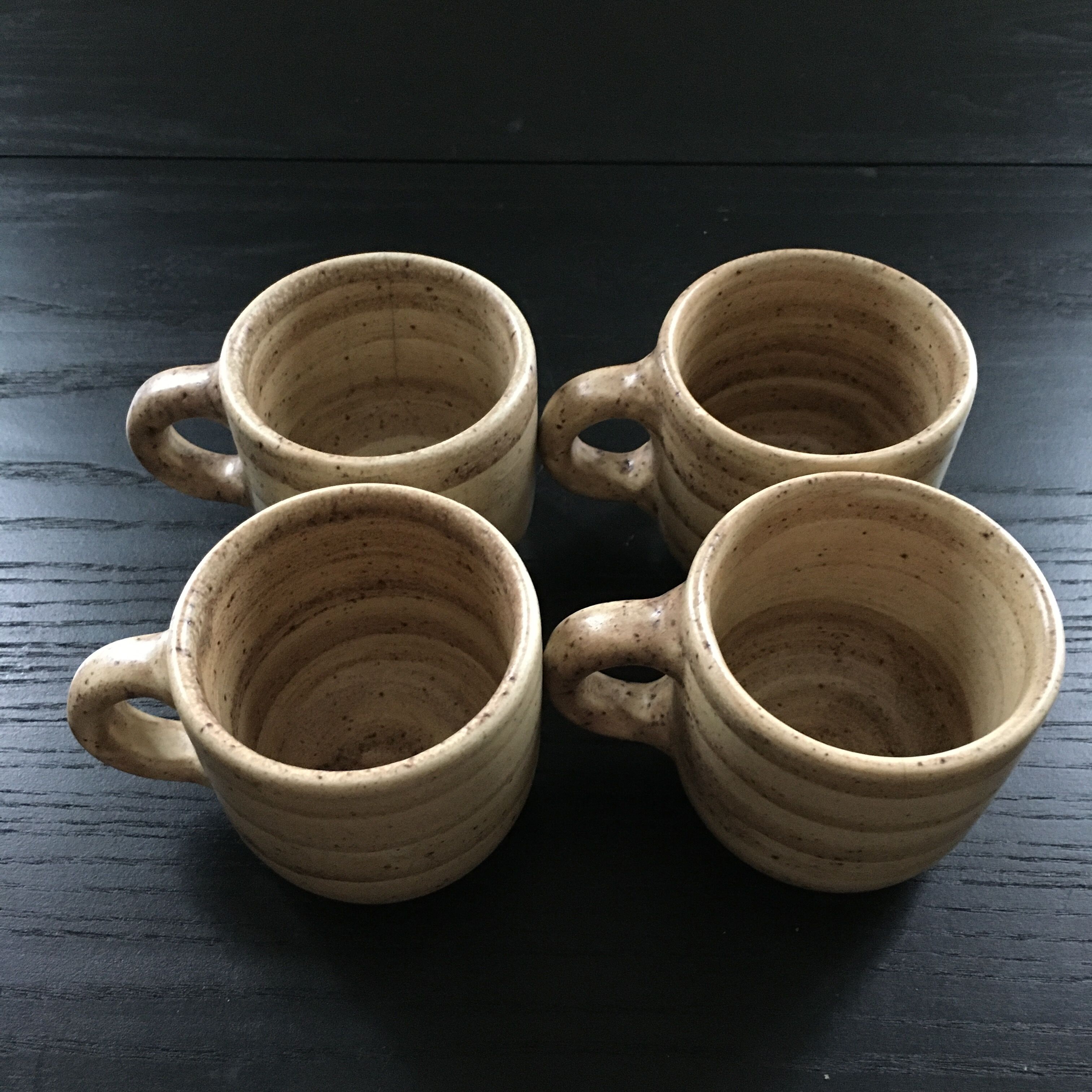 Set of 4 beige stoneware mugs.