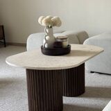 Oval coffee table in travertine and fluted wood.