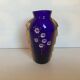 Ancient blue and gold glass vase with a floral pattern.