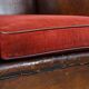 Sheepskin leather wingback chair with a red corduroy seat cushion
