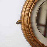 Beveled oval mirror in gilded wood