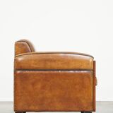 Sheepskin Art Deco design armchair with beautiful wooden details and black piping