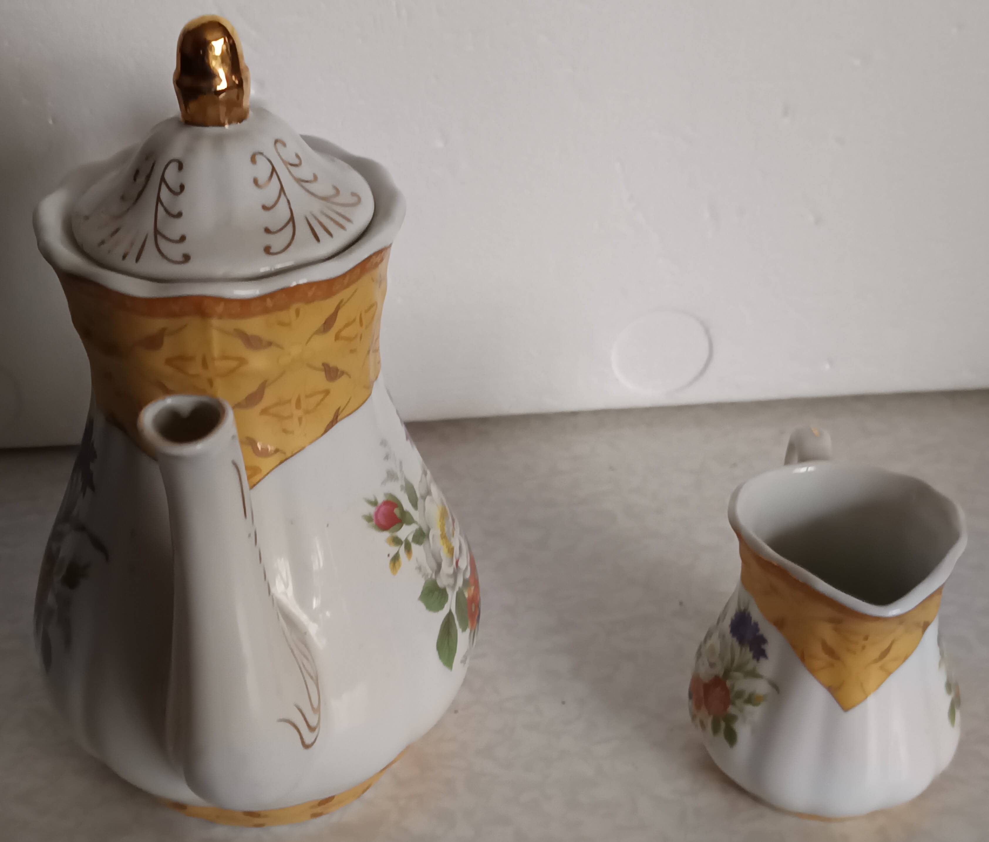 Golden porcelain teapot and coffee pot set with floral design and matching milk jug.