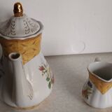 Golden porcelain teapot and coffee pot set with floral design and matching milk jug.