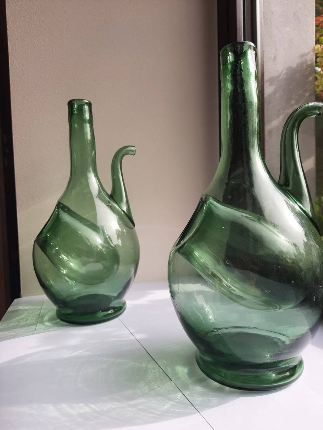 Pair of blown glass wine decanters in blue/green hues.
