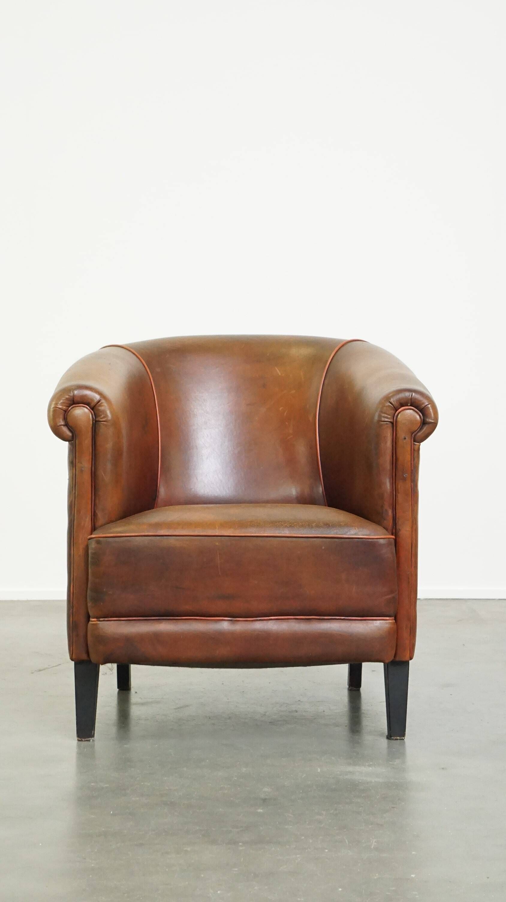 Neat, elegantly finished, cozy sheepskin club armchair with a fixed seat cushion